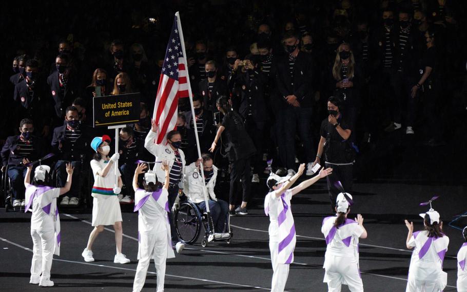 Team USA, led by Melissa Stockwell, a former Army lieutenant and Paralympic triathlon bronze medalist, and Chuck Aoki, a two-time medalist in wheelchair rugby, parade into National Stadium during the Tokyo Paralympics' opening ceremony, Tuesday, Aug. 24, 2021.
