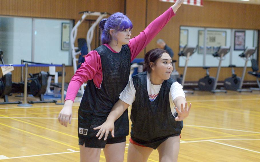 Zama girls basketball team's senior Kaitlyn McAbee and junior Deborah McClendon work on boxing out.