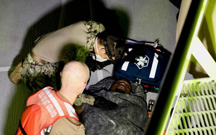 Crew members of the U.S. Coast Guard cutter Glen Harris assess a rescued migrant Jan. 5, 2022.