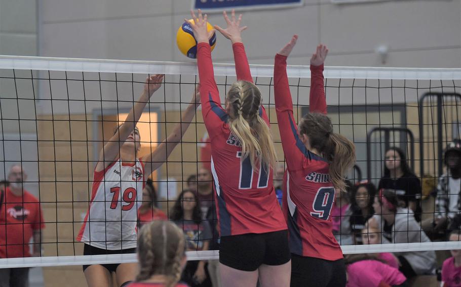 AOSR’s Cristina Nespoli spikes a ball into a wall formed by Aviano’s Kayla Graney, left, and Mayci Salmon in the DODEA-Europe girls' Division II championship match on Saturday Oct. 29, 2022, at Ramstein High School.