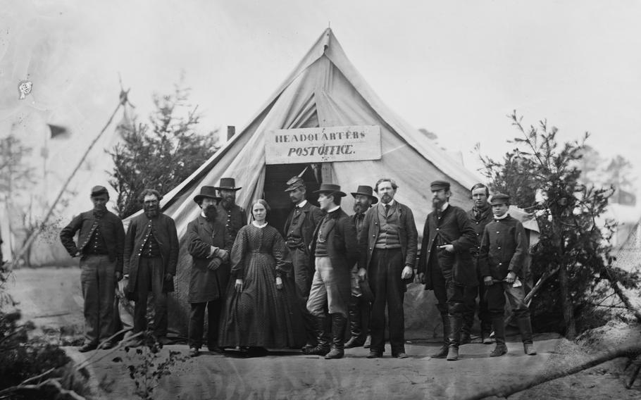 People stand in front a tent.