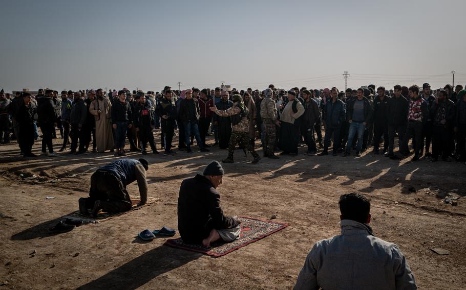Male residents of the Khishman neighborhood in Hasakah gather next to a school while the house-to-house searches were carried out. 