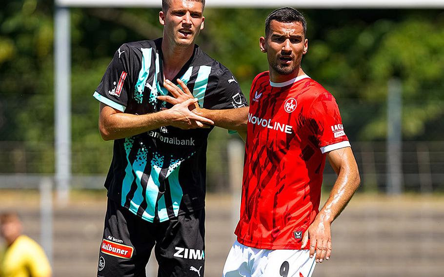 Two 1. FCK players stand together on the field.