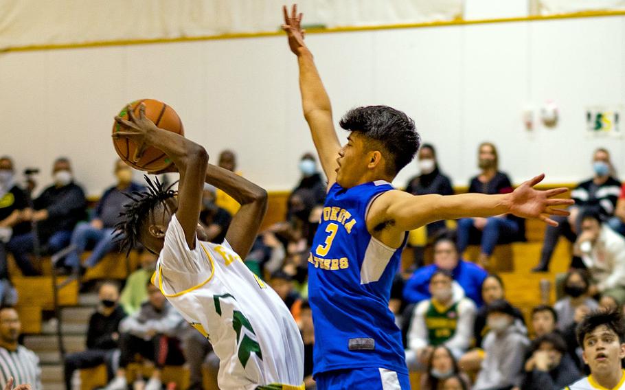 Robert D. Edgren's Messai Cain tries to shoot over Yokota's Dylan Tomas during Friday's DODEA-Japan basketball game. The Panthers won 55-28.