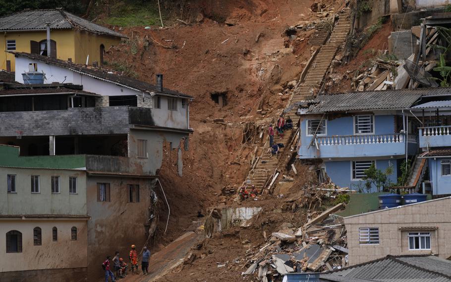 Rescue workers and residents stop for a break on the second day of rescue efforts following deadly mudslides in Petropolis, Brazil, Thursday, Feb. 17, 2022.