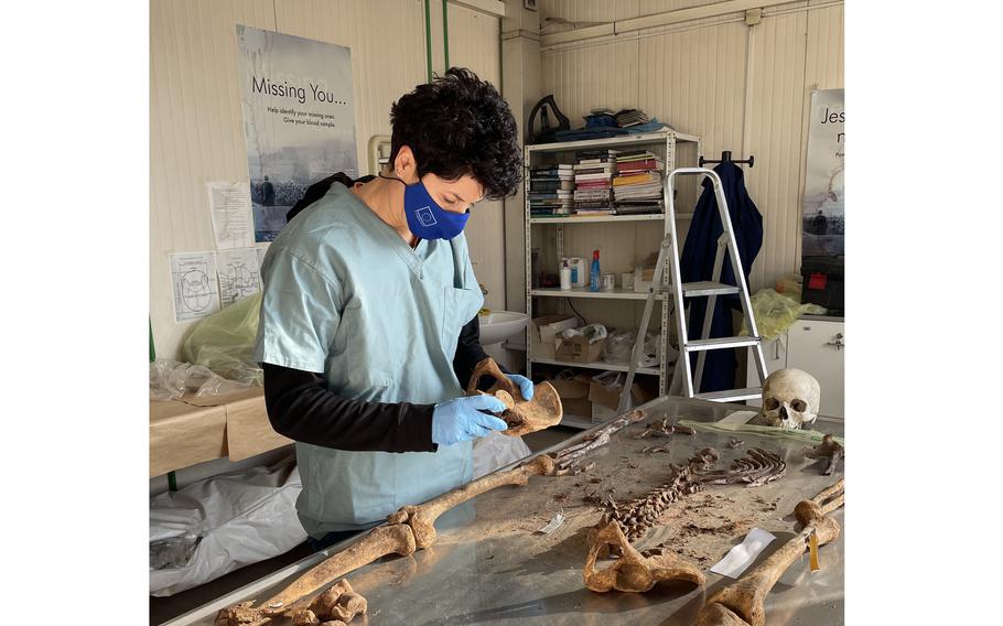 Forensic anthropologist Dragana Vucetic studies the remains of a genocide victim newly identified through DNA technology, in Tuzla, Bosnia. 