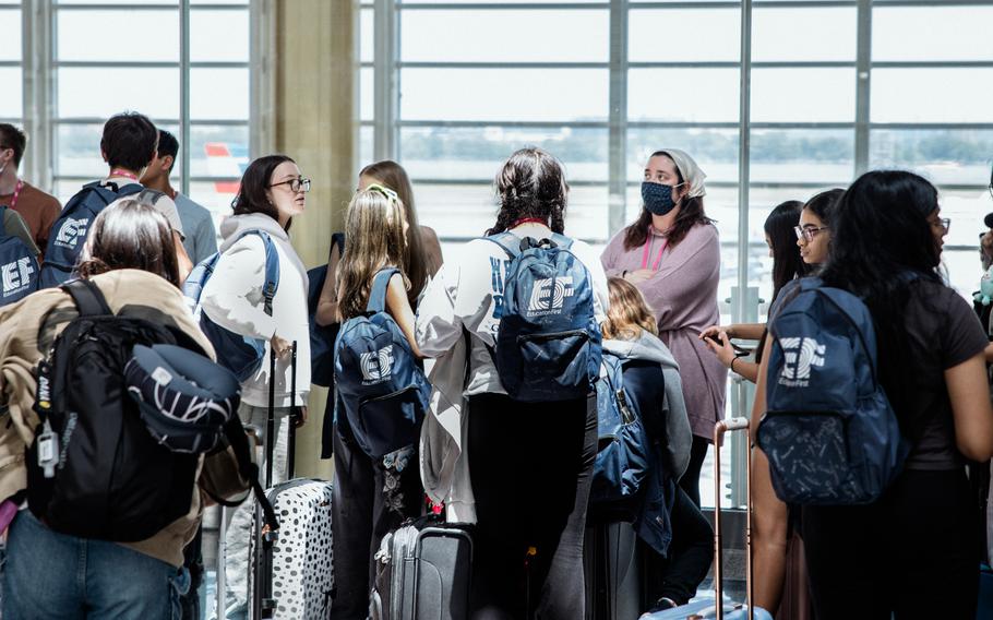 A masked person in a crowd of travelers at Reagan National Airport on May 25, 2024.