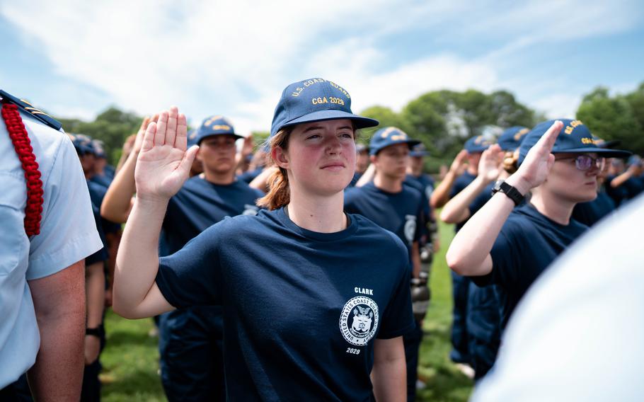 Coast Guard Academy cadets hold their hand up