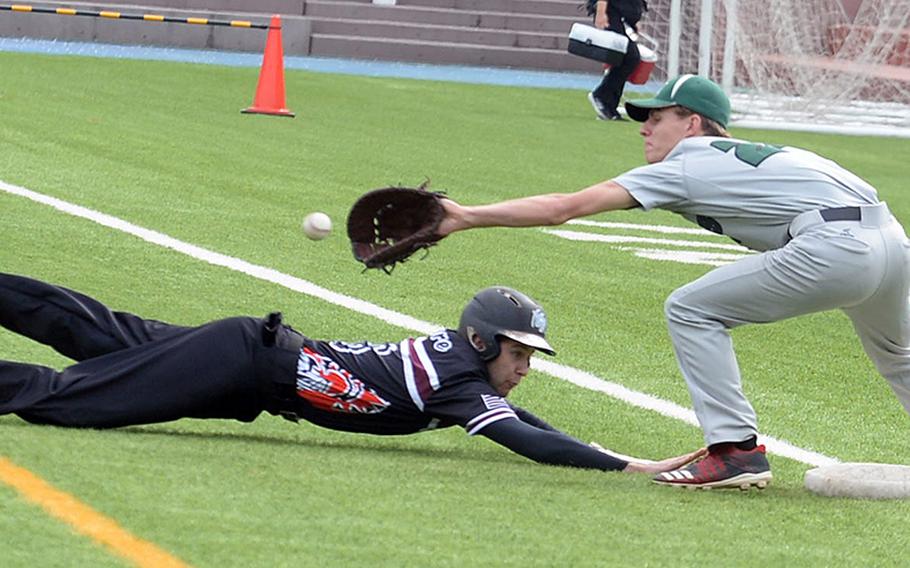 Zama's Blaeson Moore dives back to first base ahead of the pickoff throw to Kubasaki's Andrew Welte during Friday's inter-division, inter-district baseball game. The Dragons beat the Trojans 6-4.