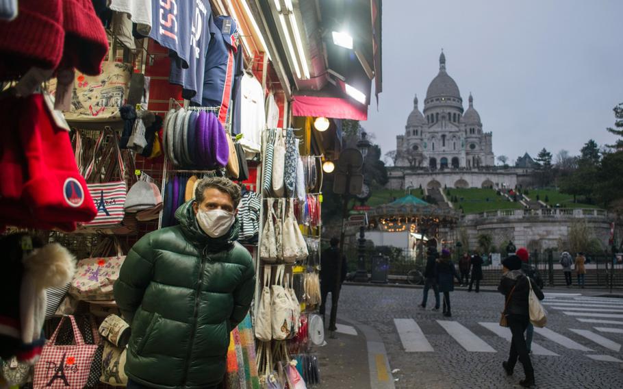 A souvenir store vendor wearing a protective mask on a near empty street near the Sacre Coeur church in Paris on Jan. 12, 2022. 