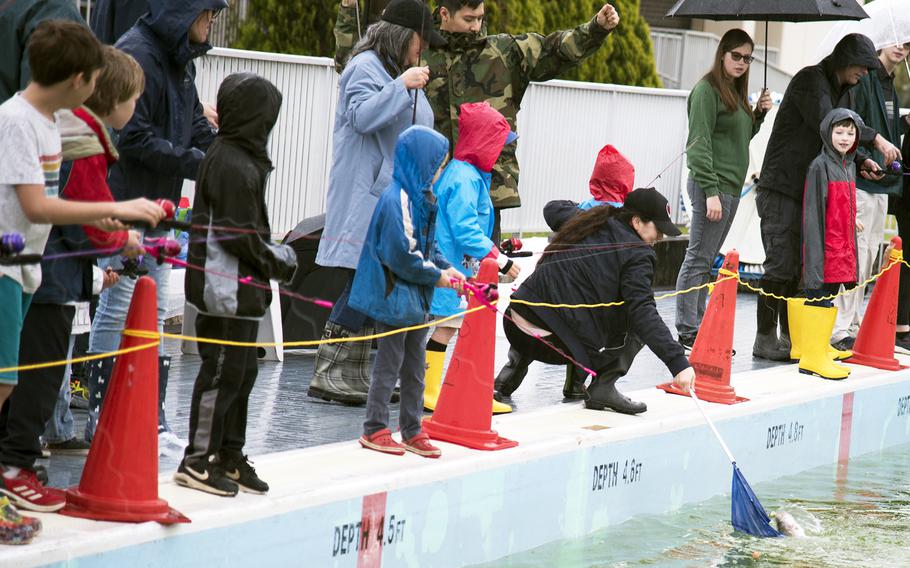 Anglers reel in a rainbow trout during the inaugural Sakana Trout Fishing Derby at Yokota Air Base, Japan, April 15, 2023.