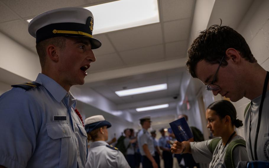 A Coast Guard member gives orders to cadets