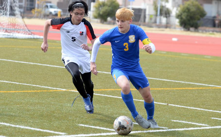 Yokota's Caleb Jones dribbles ahead of Nile C. Kinnick's Jin Tiong during the championship match in the Perry Cup soccer tournament. The Red Devils shut out the Panthers 2-0.