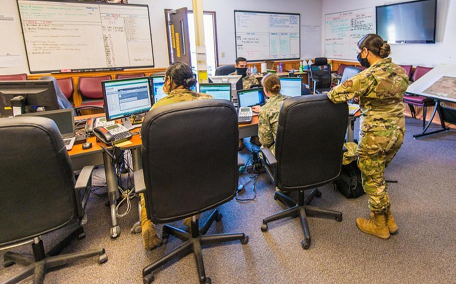Airmen wear masks while at work at RAF Mildenhall, England.  The base is requiring masks to be worn indoors by all, including the fully vaccinated, following a Defense Department directive mandating them where there is "substantial or high community transmission" of the coronavirus.