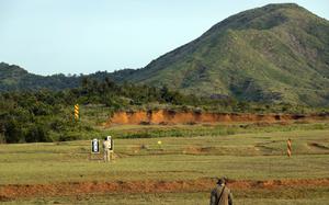 A shooting range outside near a green hill.