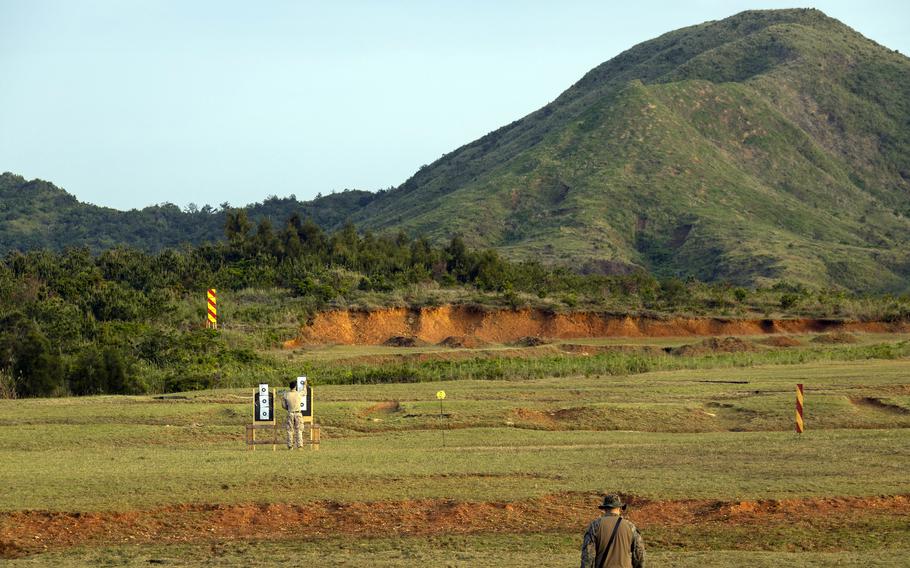 A shooting range outside near a green hill.