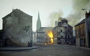 FILE - In this February 1972 file photo, a building burns in the bogside district of Londonderry, Northern Ireland, in the aftermath of Bloody Sunday, one of the the most notorious events of "The Troubles." Fifteen British soldiers who allegedly lied to an inquiry into Bloody Sunday, one of the deadliest days of the decades-long Northern Ireland conflict, will not face perjury charges, prosecutors said Friday. (AP Photo/Michel Laurent, File)
