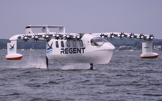 A winged passenger ferry glides over the surface of water in a bay.