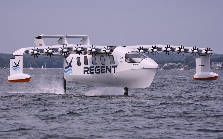 A winged passenger ferry glides over the surface of water in a bay.