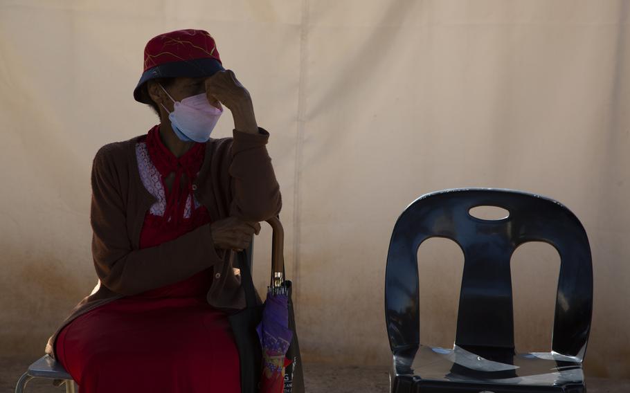 A woman waits in a queue to be screened for COVID-19 at a testing centre in Soweto, South Africa, Wednesday, May 11, 2022.