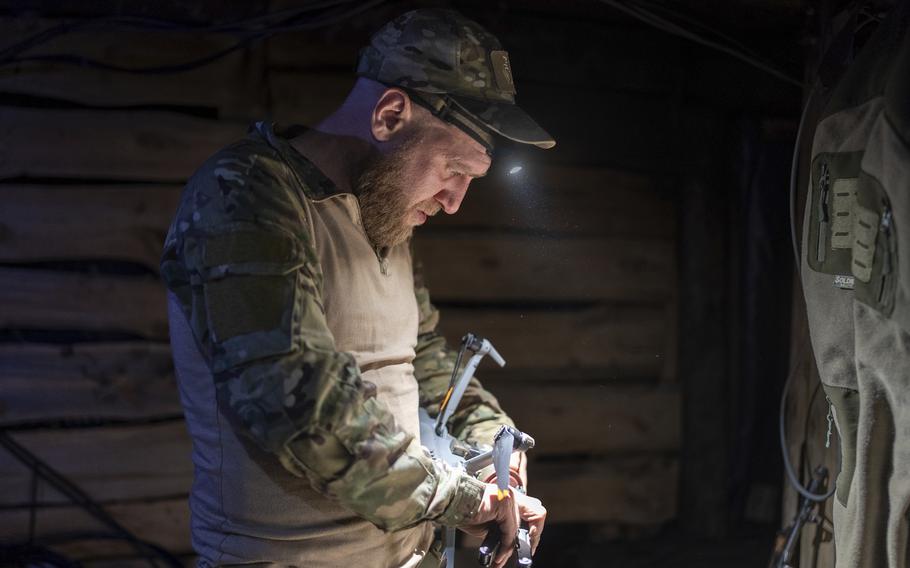 A Ukrainian service member known by call sign Mamay attaches drop bomb to a drone in the trenches at the front line, a few miles from Bakhmut, Donetsk region, Ukraine, Tuesday, April 23, 2024. 
