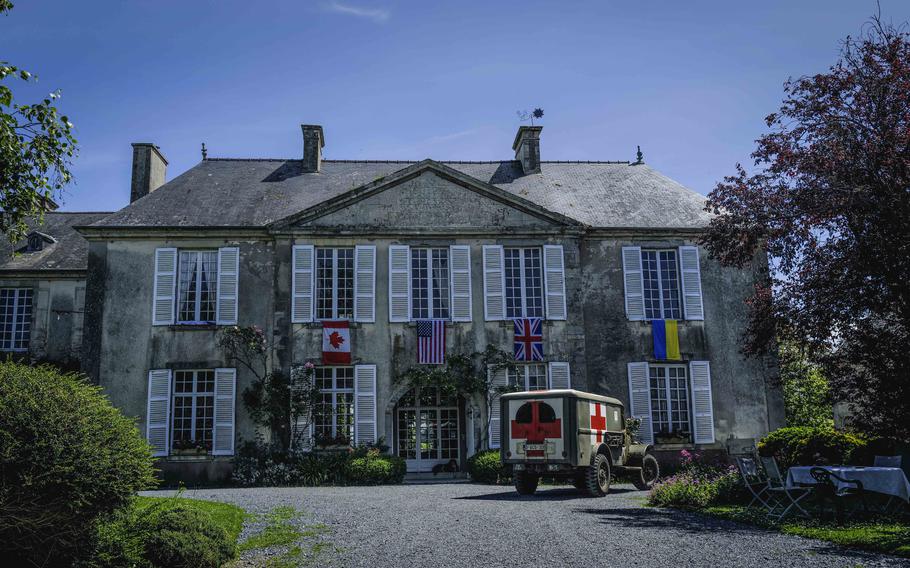 A wartime ambulance truck parked in front of Chateau Vouilly in Normandy, France, during a reenactment event. The chateau was the first Allied press camp established after the D-Day invasion.