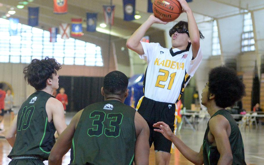 Kadena's Angel Torrado shoots in front of Kubasaki's Troy Harris, T.J. Reese and Zyiere Paul during Sunday's third-place game, won by Kubasaki 63-56.