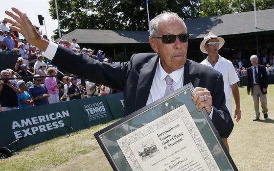 FILE - Nick Bollettieri holds his plaque as he waves to the crowd after his induction into the International Tennis Hall of Fame in Newport, R.I., Saturday, July 12, 2014. Nick Bollettieri, the Hall of Fame tennis coach who worked with some of the sport’s biggest stars, and founded an academy that revolutionized the development of young athletes, has died. He was 91. Bollettieri passed away Sunday night, Dec. 4, 2022, at home in Florida after a series of health issues, his manager, Steve Shulla, said in a telephone interview with The Associated Press on Monday. AP Photo/Michael Dwyer)