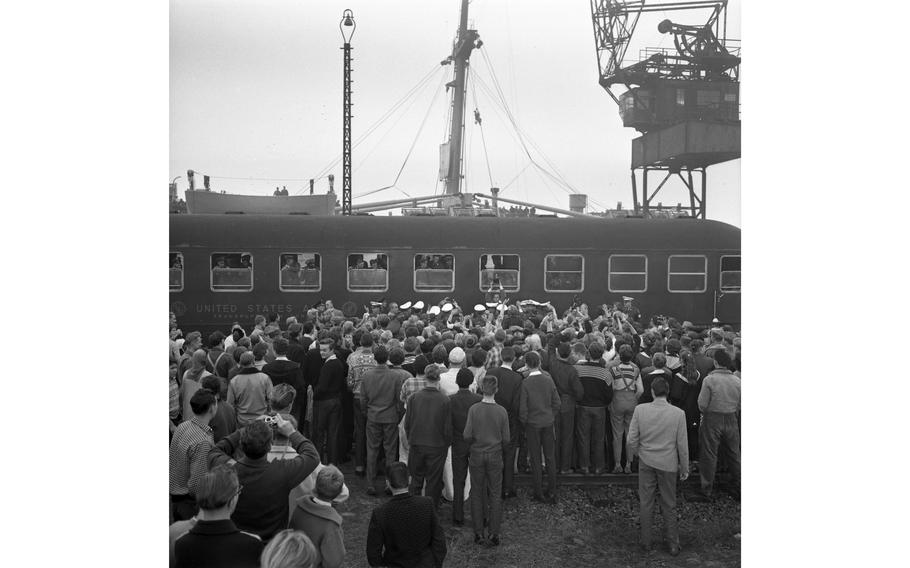 A troop train with Pvt. Elvis Presley on board leaves Bremerhaven, Germany, heading for Friedberg, near Frankfurt, as throngs of fan stand around hoping for one last glimpse of the famous soldier. During the half-hour wait before the train left, Presley appeared at the window several times to sign autographs and acknowledge the cheers of troops and sailors from the USS Randall that brought them and Presley to Bremerhaven.