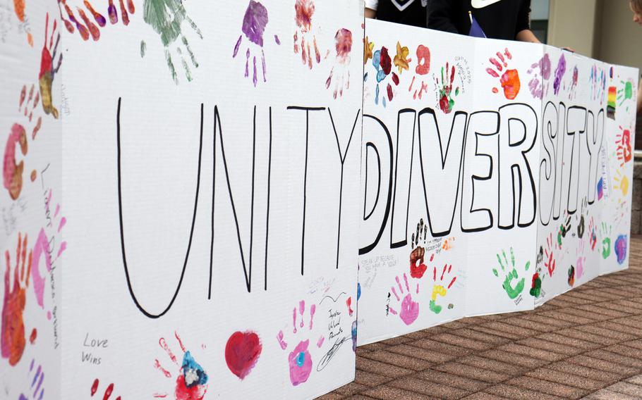 A close-up view of a long banner reading “Unity Diversity” with several colored handprints.