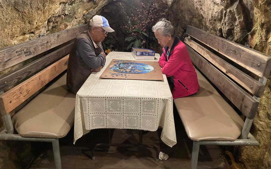 Hak (left) and Ung Shin spend time in a tunnel at the Merry Widow Health Mine in Basin, Montana, on June 30, 2021 piecing together a puzzle. For more than a decade, the California couple have made the trip to expose themselves to radioactive radon, which they say keeps them healthy. 