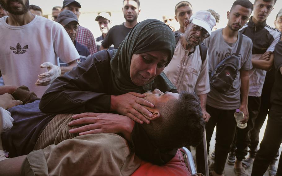 A woman cradles her adult son.