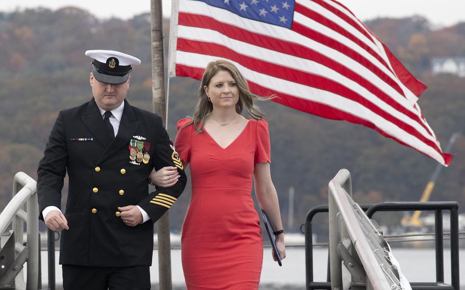 Nikki Stratton, right, is escorted aboard the USS Arizona submarine on Oct. 27, 2023, at Submarine Base New London, Conn. The granddaughter of a survivor of the sinking of the battleship USS Arizona at Pearl Harbor on Dec. 7, 1941, Stratton is the official sponsor of the sub.