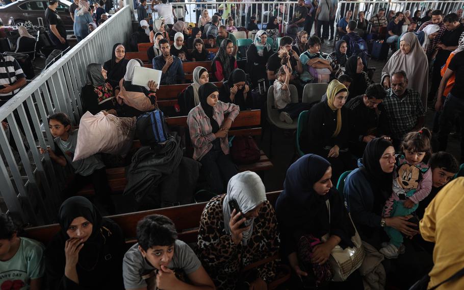Palestinians with foreign passports wait to cross into Egypt at the Rafah border gate on Nov. 1, 2023.