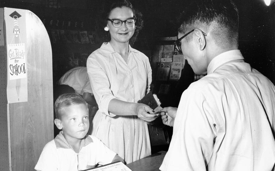 Gary Howard, 6, gets an ABC tablet with his mother at the Chitose Base Exchange at Chitose Air Base on Sept. 2, 1957. 