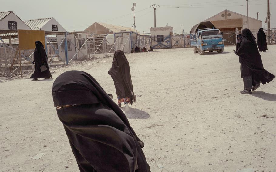 Syrian and Iraqi women are seen near the market in al-Hol, a camp housing displaced people in Hasakah province in northeast Syria. 