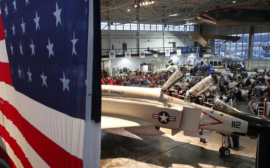 The F-4 Phantom is displayed in front of a large flag as more than 250 people attend the Veterans Day Celebration on Nov. 13, 2021, at the MAPS Air Museum.