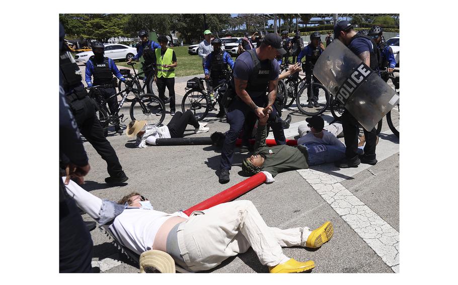 Police arrest protesters lying down in an intersection in Miami, Florida, on Monday, April 15, 2024.