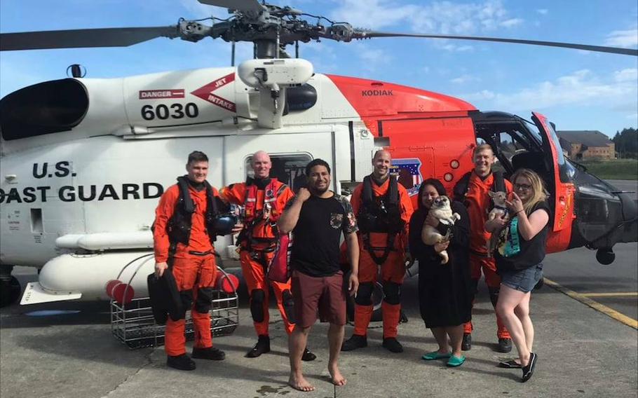 Members of the Alaska's U.S. Coast Guard Air Station in Kodiak rescued Nation Sega, left, Lepa Sega, middle, and Hollie Spence (and their pups) on Saturday after their pink flamingo raft was swept across Monashka Bay.