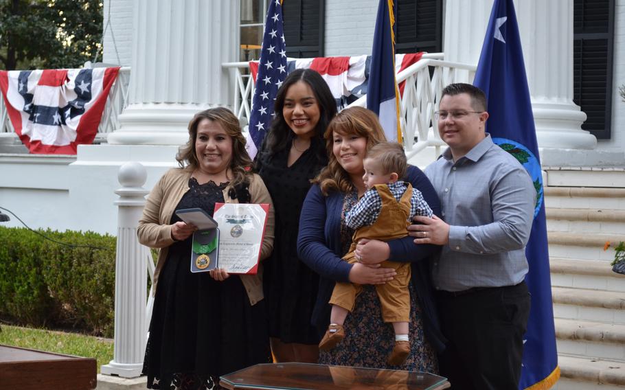 Genny Stopani, seen with her family Wednesday, March 2, 2022, holds a Texas Legislative Medal of Honor presented to her on behalf of her great-grandfather, Army Pvt. Marcelino Serna, who served during World War I. 