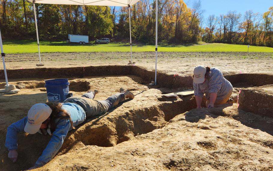 Jane C. Skinner and Samantha Muscella excavate post holes at the bottom of a stockade trench, Thursday, Oct. 27, 2022, in York, Pa. Researchers say they have solved a decades-old riddle by finding remnants of the stockade and therefore the site of a prison camp in York, that housed British soldiers for nearly two years during the American Revolutionary War.
