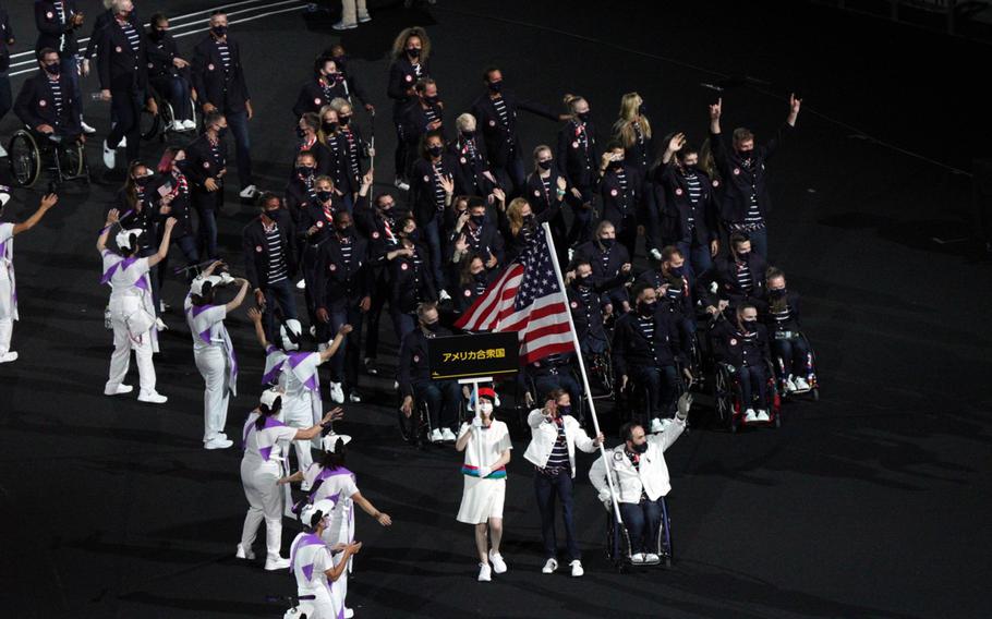 Team USA, led by Melissa Stockwell, a former Army lieutenant and Paralympic triathlon bronze medalist, and Chuck Aoki, a two-time medalist in wheelchair rugby, parade into National Stadium during the Tokyo Paralympics' opening ceremony, Tuesday, Aug. 24, 2021. 