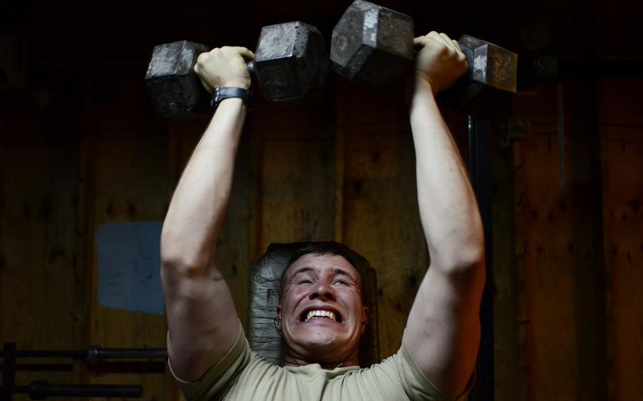 Pfc. Jacob Lunceford, one of Combat Outpost Sabari's gym regulars, strains to get his dumbbells up at the end of a set. 