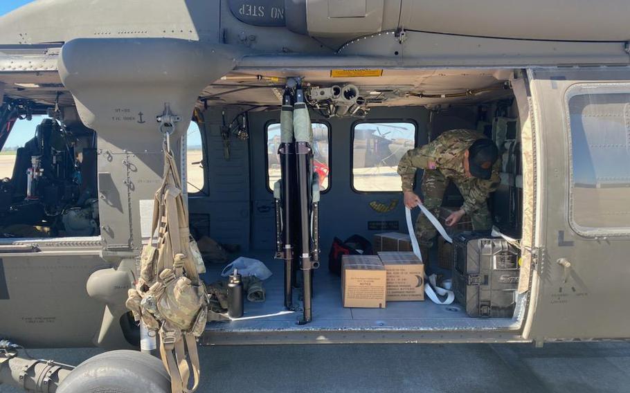 A member of the California National Guard prepares a UH-60 Blackhawk helicopter to launch from Joint Forces Training Base-Los Alamitos, Thursday, March 2, 2023, in support of San Bernardino County and state agencies to help people who have been trapped in their homes for several days by heavy snow.