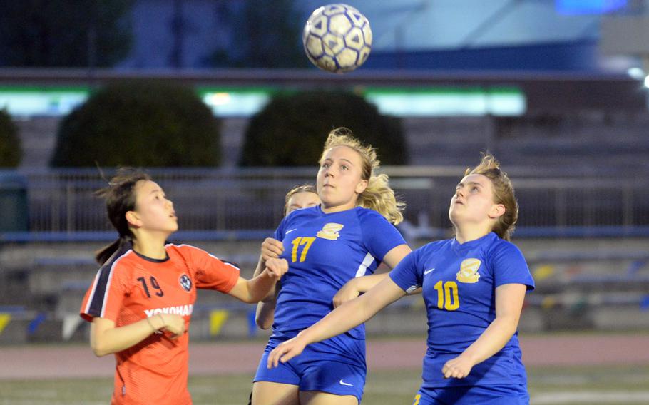 Yokohama International's Myuyen Hiseda and Yokota's Giselle Pinard and Anais Pinard try to head the ball during Wednesday's Kanto Plain girls soccer match. The Panthers won 4-1.