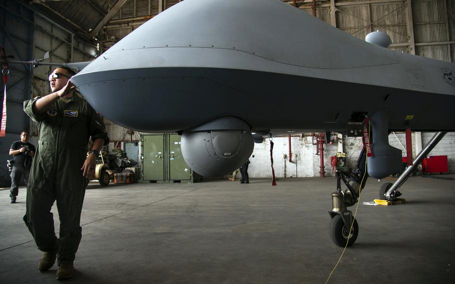 Capt. Angelo Tapalla, an unmanned aerial vehicle pilot with the California Air National Guard, briefs Philippine navy sailors about the MQ-9 Reaper at the former home of Naval Air Station Cubi Point, Philippines, Sunday, April 23, 2023.