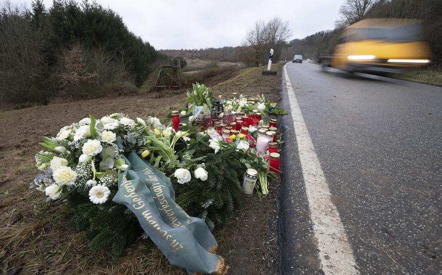 Flowers and candles stand in Ulmet, near Kusel, Germany, Friday, Feb. 4, 2022 at the scene where two police officers were shot during a traffic stop.