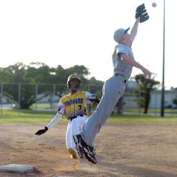 The throw comes in too high for Kubasaki third baseman Lukas Gaines as Kadena baserunner Adrian Wilson slides in safe during Monday's DODEA-Okinawa baseball game. Wilson stole four bases as the Panthers won 7-6 in eight innings.