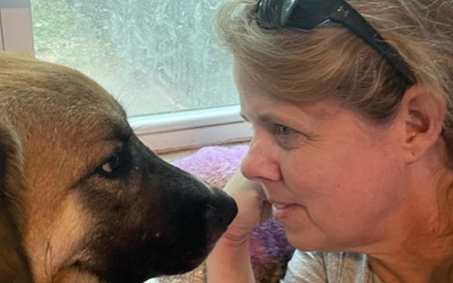 Stephanie Hall, an Air Force chief warrant officer, plays with Mollie, a dog from her deployment to Afghanistan that she brought to America in 2021. Hall worked to bring the Afghan pilots and their families she trained on that deployment to America but said she has been disappointed in how much red tape she has faced.