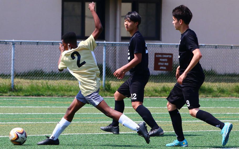 Humphreys' Devin McDaniel gets twisted around as he plays the ball in front of Daegu's Jason Noak and David Tak during Saturday's DODEA-Korea soccer match. The Blackhawks won 4-0.